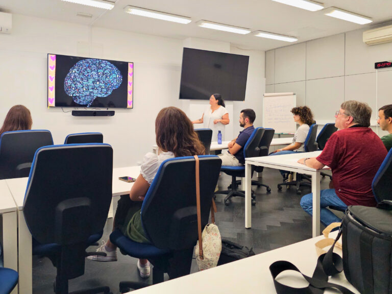 Carla Boura and group of PhD students sitting during a wellbeing the PhD Student Meetup workshop on mental health.